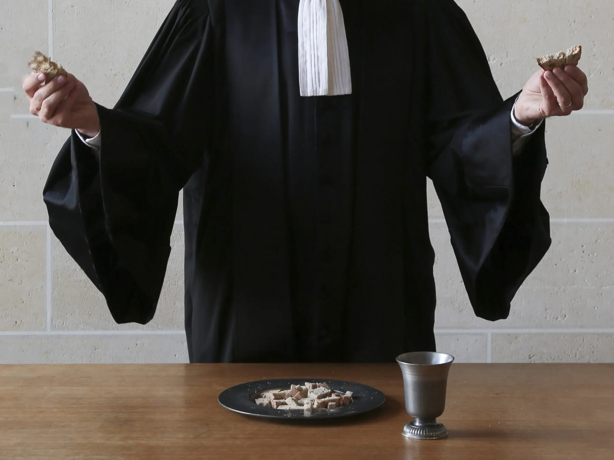 pasteur en robe célébrant la Cène